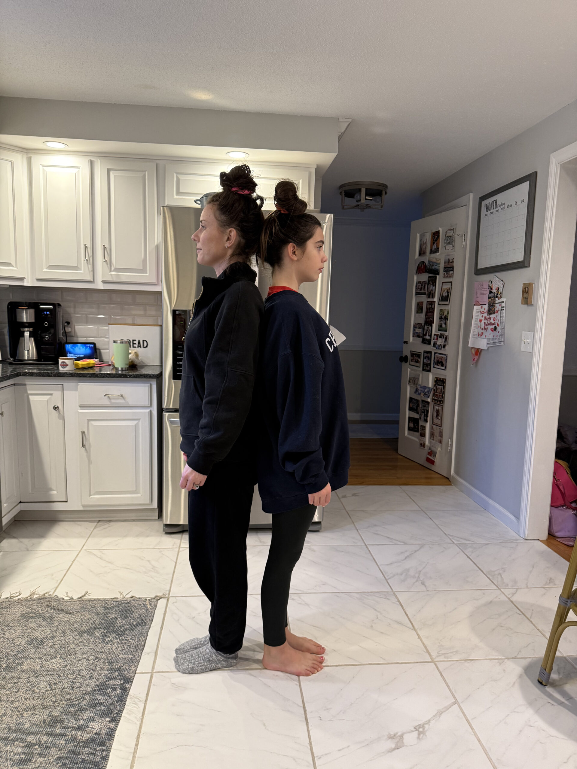 Mom and Daughter measuring height by standing back to back 
