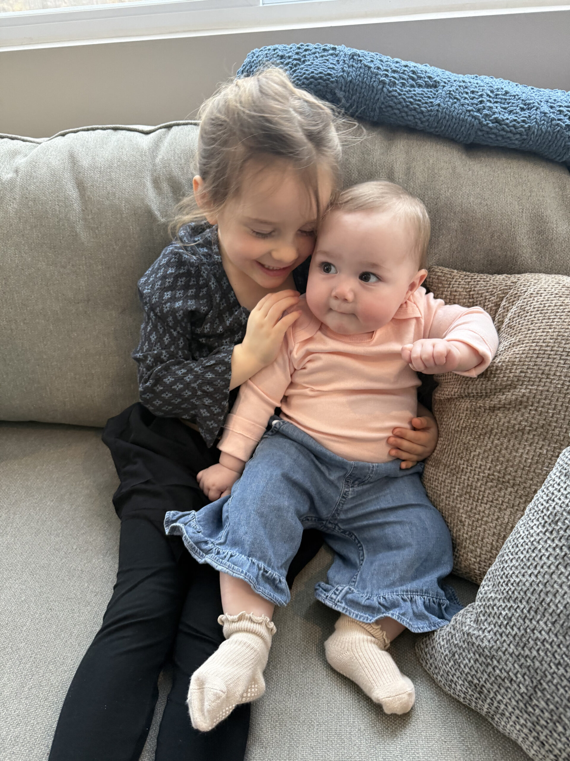 Four year old holding nine month old baby 