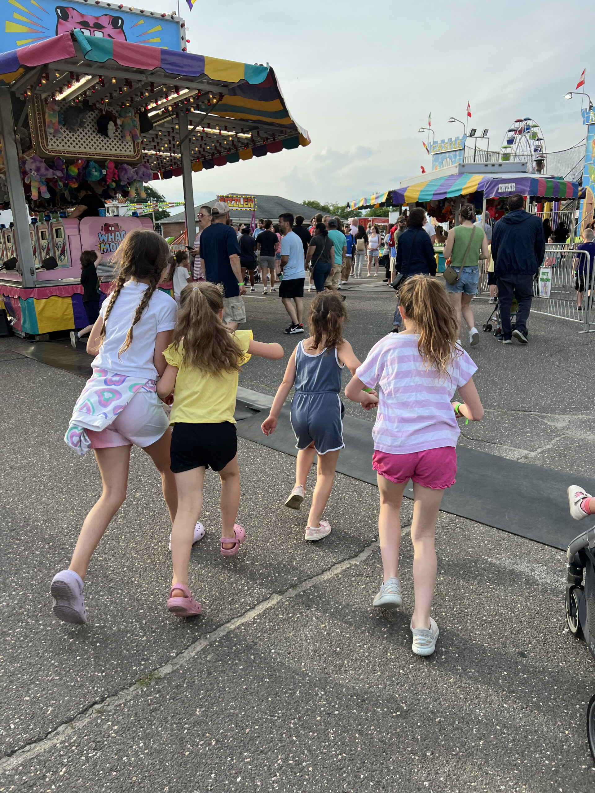 little girls running to different rides at church bazaar