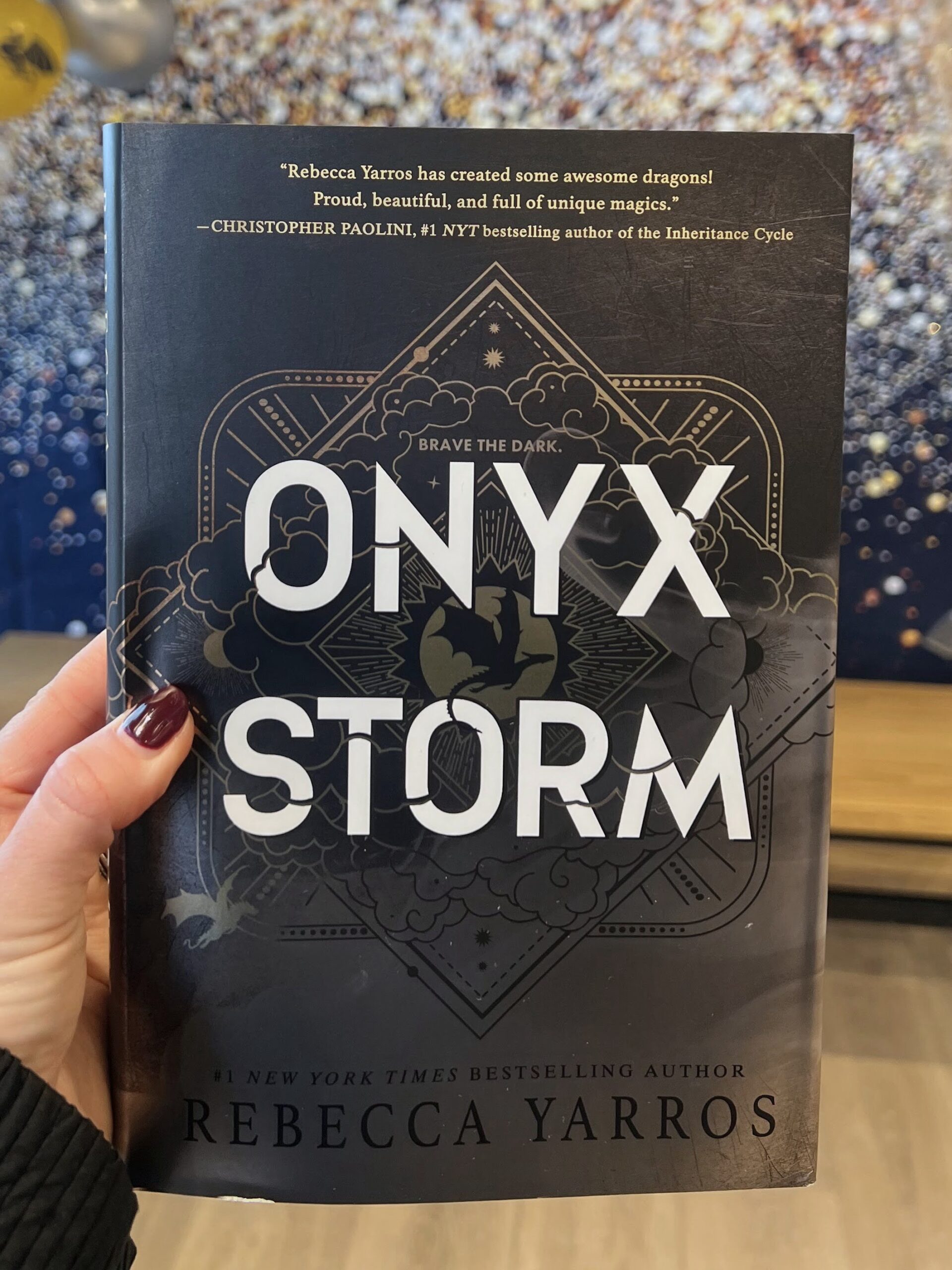 Onyx Storm book in front of glitter wall at release party at Barnes and Noble