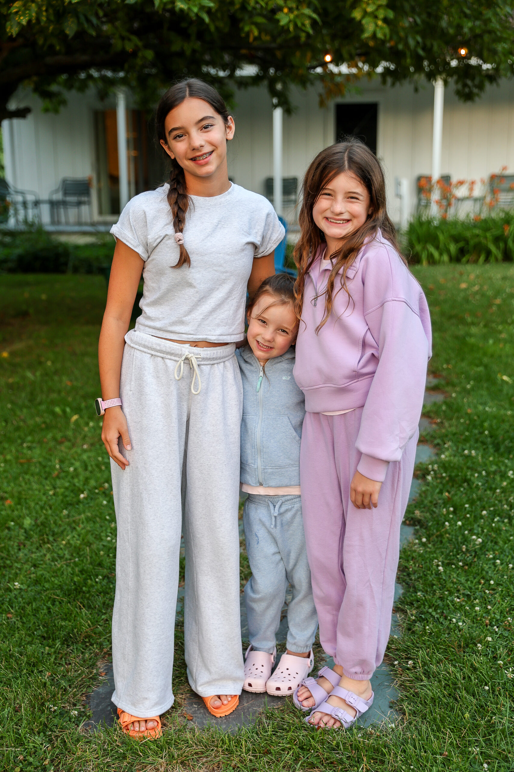 4 and a half year old with big sisters in lounge clothes standing outside a cottage at Basin Harbor