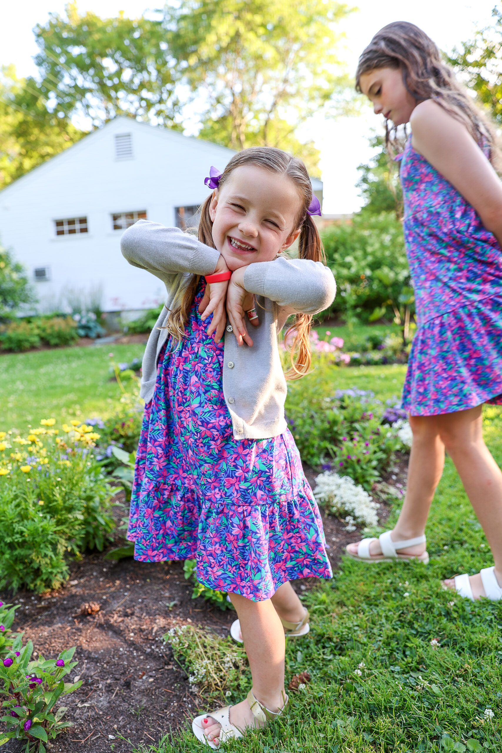 4 and a half year old girl wearing a flower dress smiling and being silly at Basin Harbor