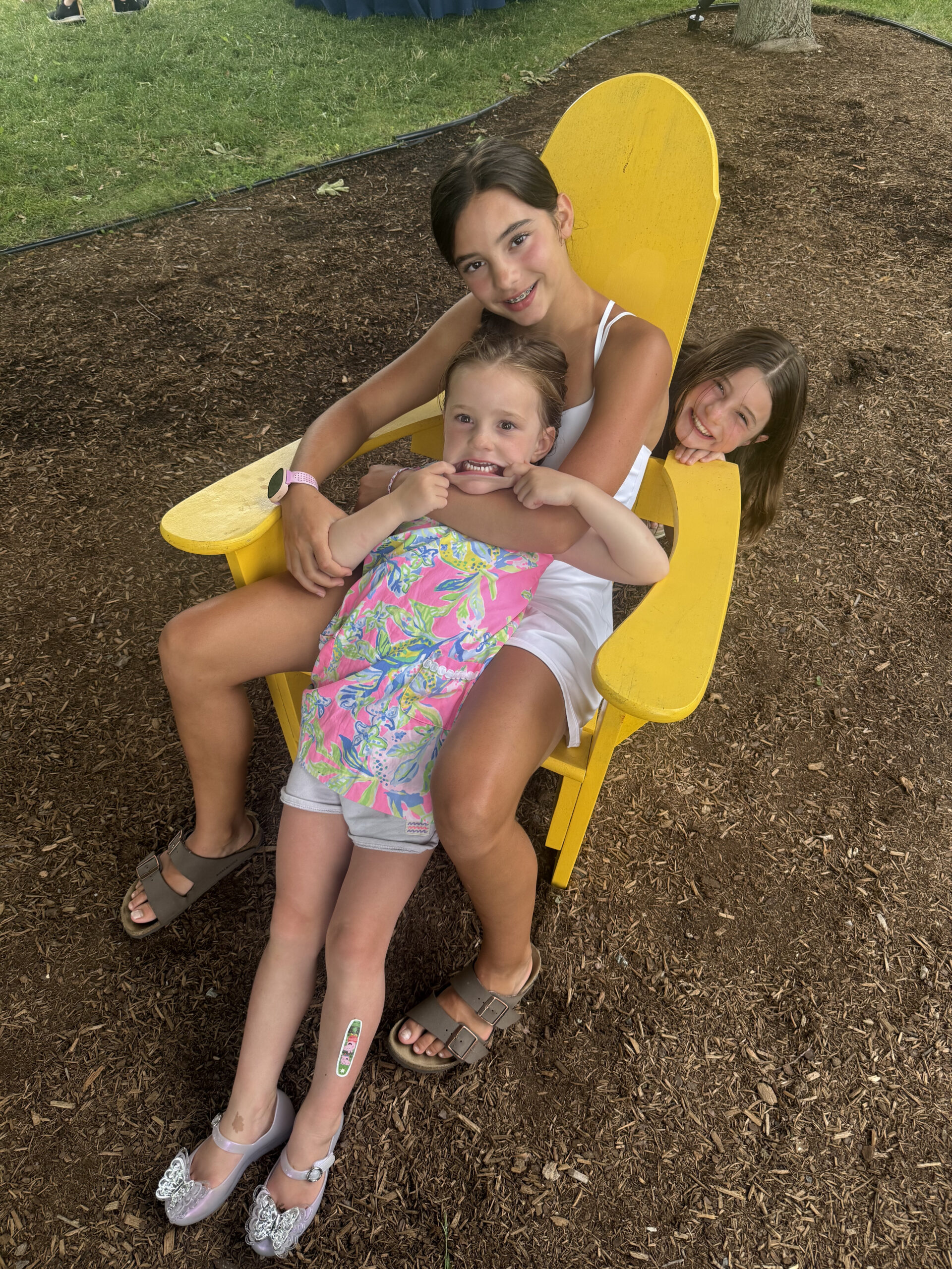 silly three daughters family picture sitting in yellow adirondack chair basin harbor summer confessions