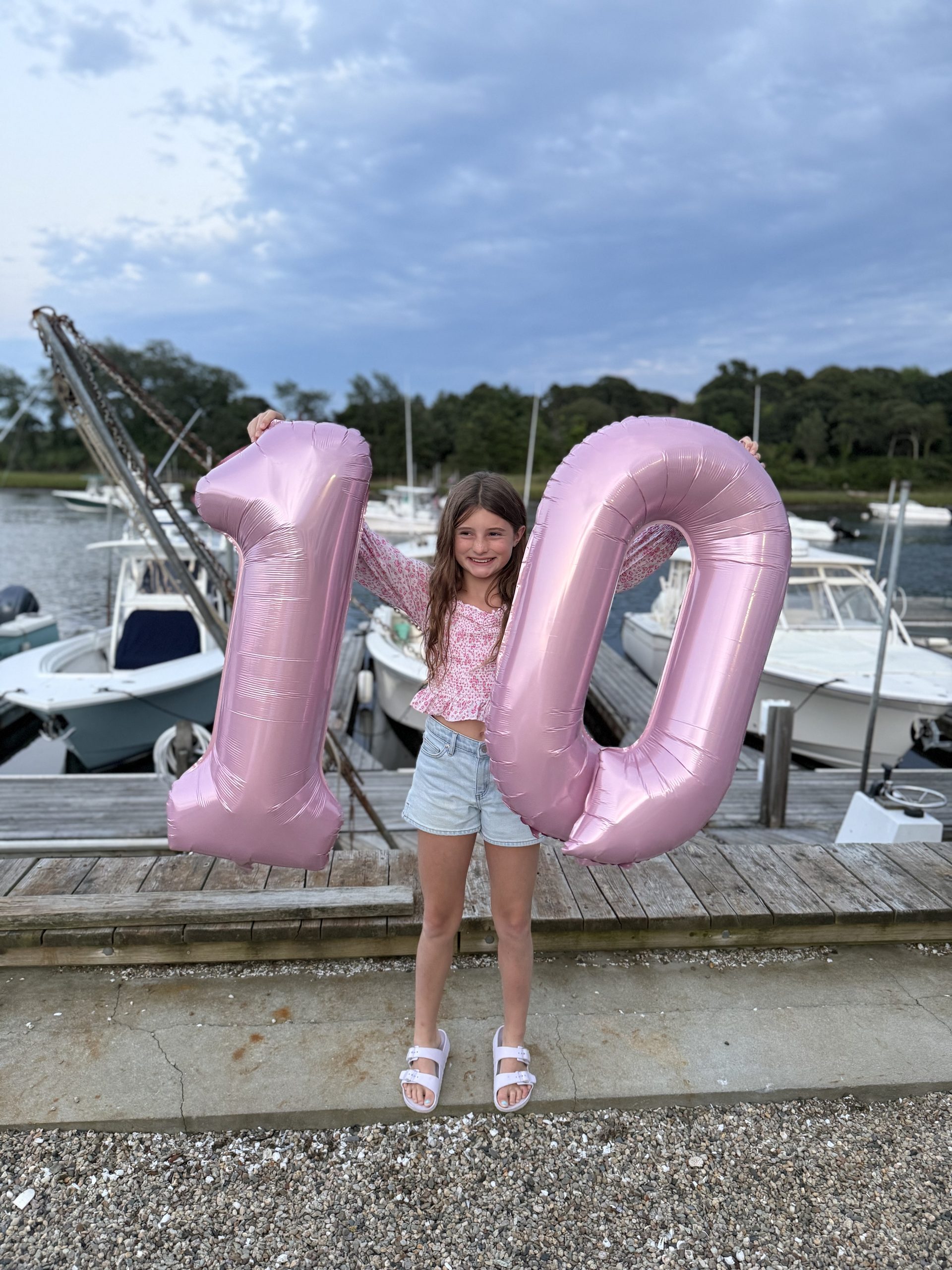 Ailey 10 years old holding 1 0 balloons